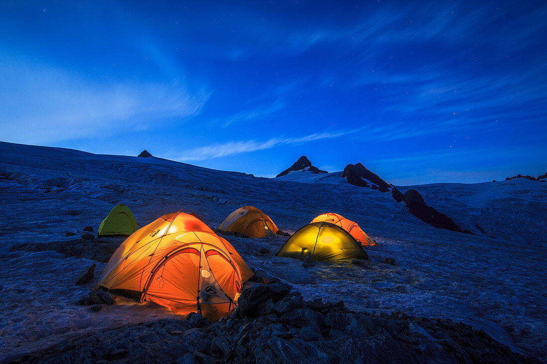 Glacier campsite with illuminated tents at Mount Shuksan, North Cascades National Park, Washington State, USA