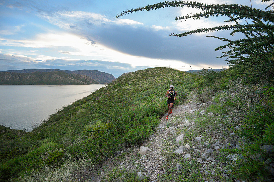 Man trail running in area of Presa Zarco in Durango, Mexico