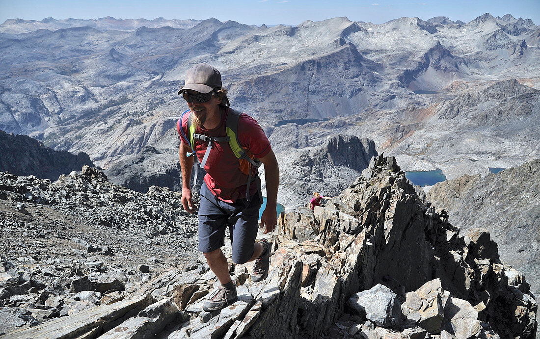 Backpackers climbing Mt Ritter on trek of Sierra High Route in Minarets Wilderness, Inyo National Forest, California, USA
