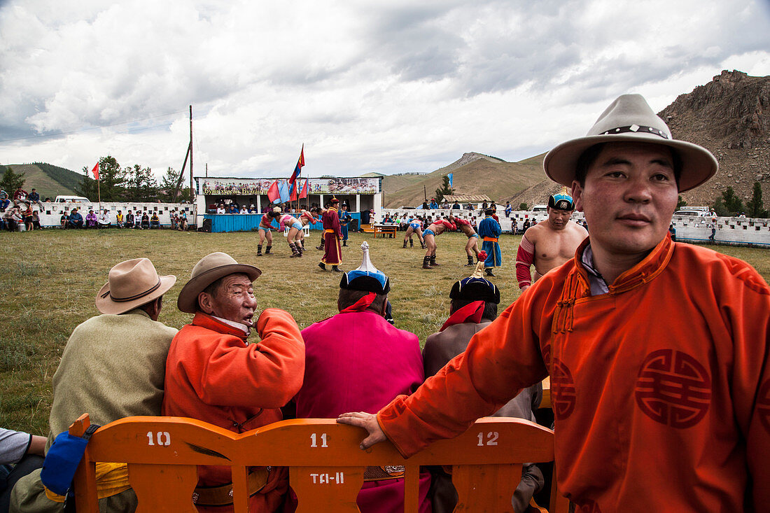 Wrestling match Judges. A wrestling match is one of the main attractions of Annual Naadam Festival. Only men participate in wrestling match wearing shoulder vest zodog and snug shorts shuudag. They also perform eagle dance, devekh to honor judges and festival attendants. Titles are given to winners of a number of rounds: Falcon to those winning five rounds, Elephant for seven rounds, and Lion to the one winning the whole tournament. Bunkhan Valley, Arkhangai Province, Mongolia.