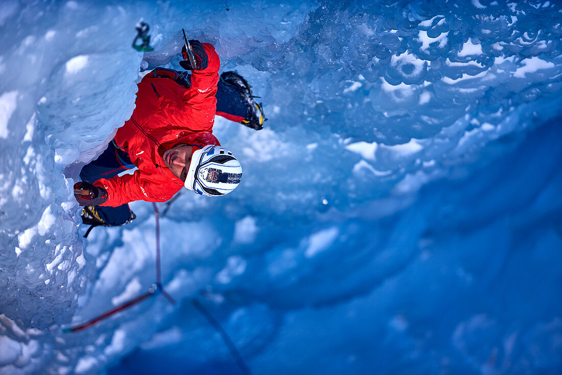 Ice climber climbing Fluido azzurro icefall, simplon pass, Valais Canton, Switzerland