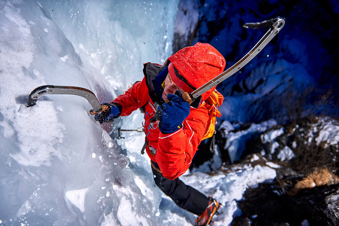 Ice climber climbing Fluido azzurro icefall, simplon pass, Valais Canton, Switzerland