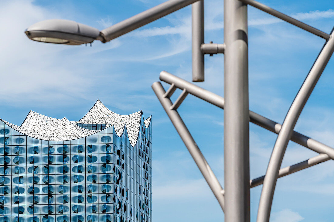 Eine moderne Straßenlampe mit der Glasfassade des Konzerthauses Elbphilharmonie, Hafencity, Hamburg, Deutschland