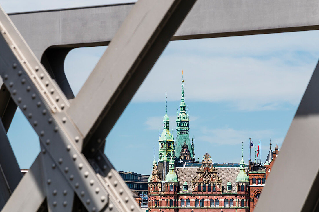 Turm des Rathauses und alte Gebäude in der Speicherstadt, eingerahmt von einer alten Brücke, Hafencity, Hamburg