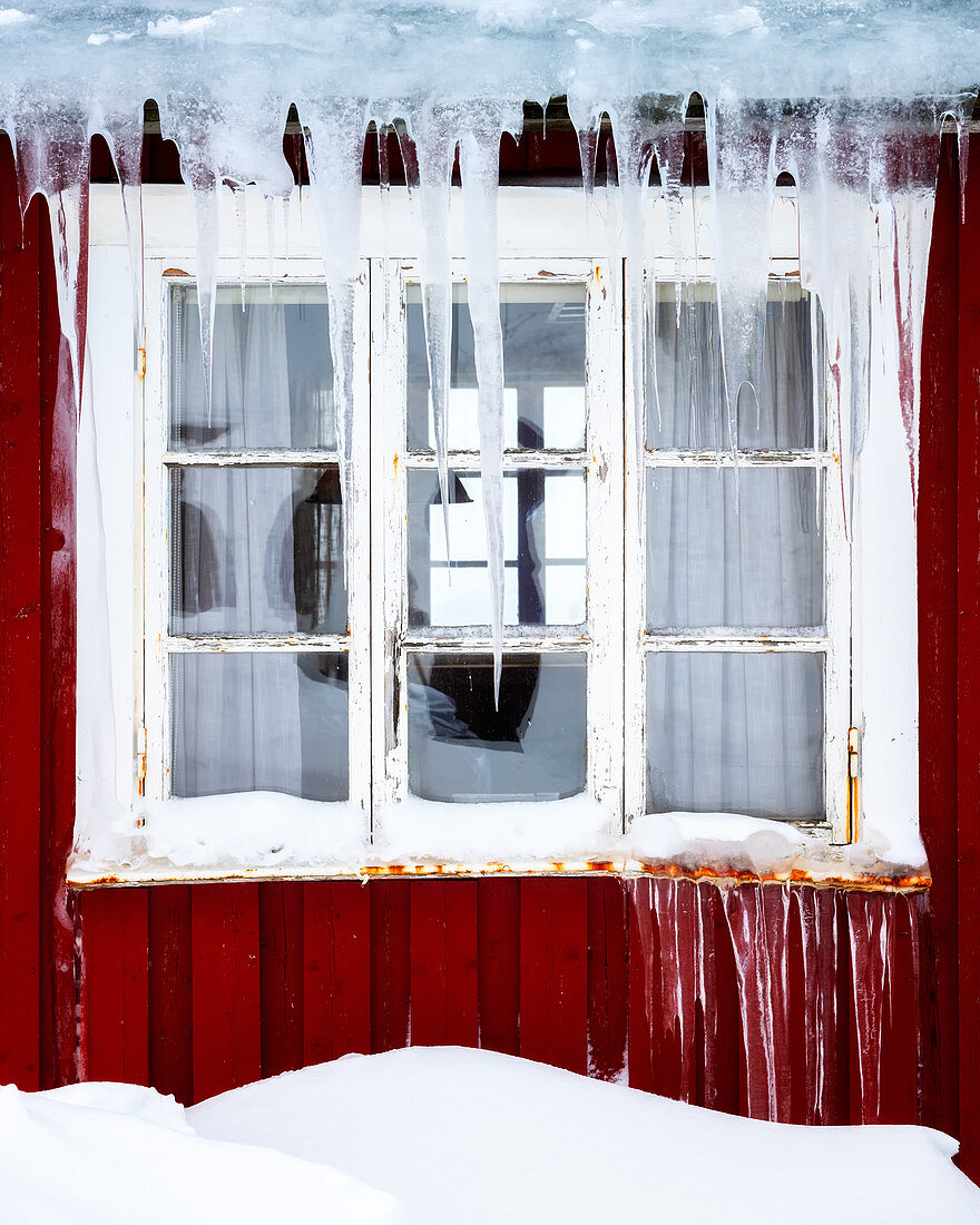 Gefrorene Eiszapfen auf einem traditionellen Rorbu-Fenster im Winter, Nordland, Lofoten-Inseln, Norwegen, Europa
