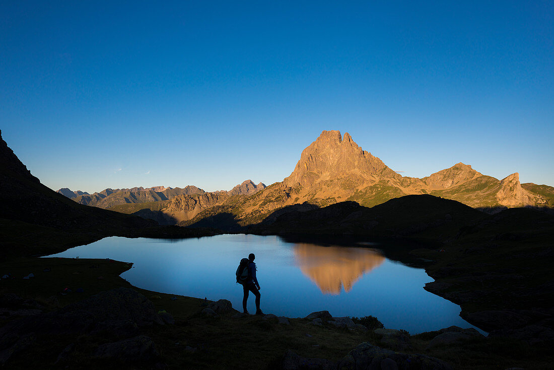 Taking in the view of Midi d'Ossau beyond Lac Gentau beside the GR10 trekking route in the French Pyrenees, Pyrenees Atlantiques, France, Europe