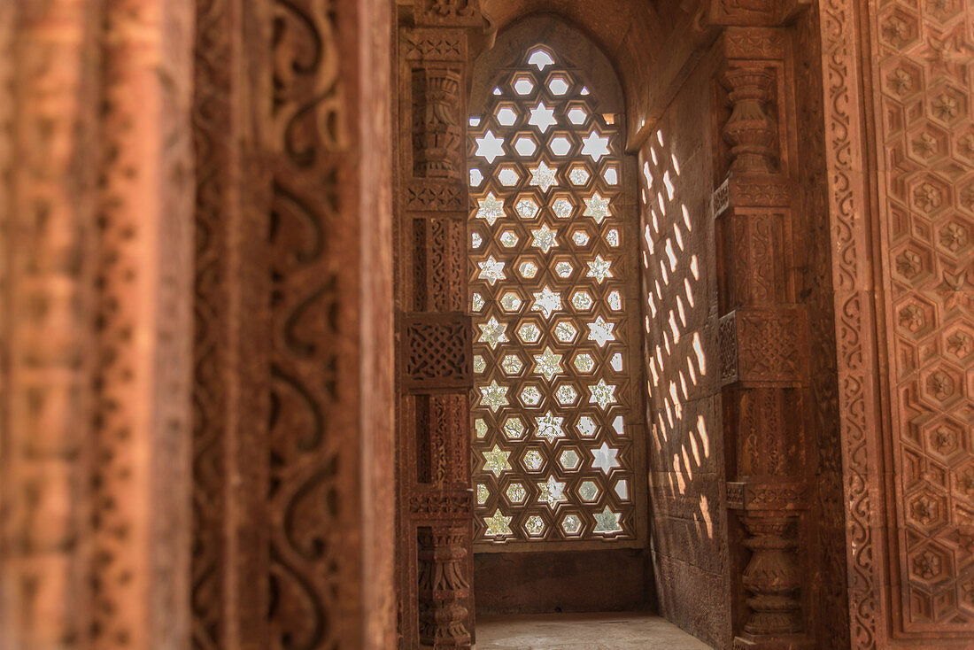 Die komplizierten Fensterschnitzereien bieten schöne Schatten in Qutub Minar, UNESCO-Weltkulturerbe, Neu-Delhi, Indien, Asien