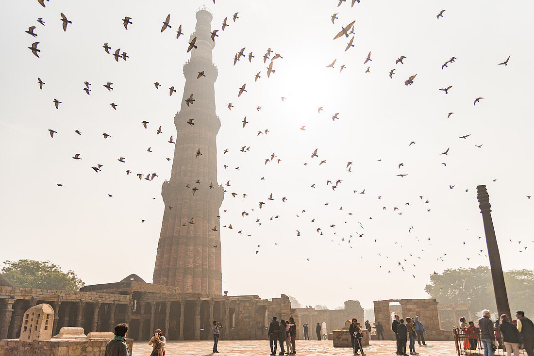 Vögel fliegen über Besucher, Qutub Minar, UNESCO-Welterbestätte, Neu-Delhi, Indien, Asien