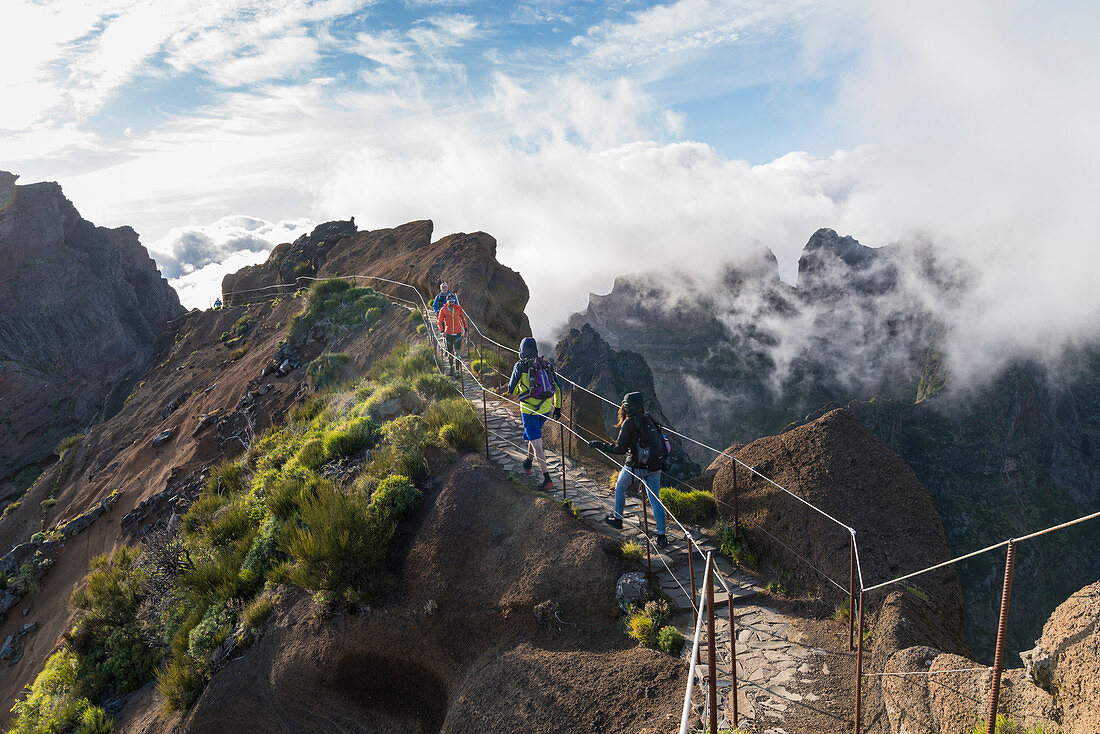 Hikers walking on Vereda do Areeiro, the trail that links Pico Ruivo to Pico do Arieiro, Funchal, Madeira, Portugal, Atlantic, Europe