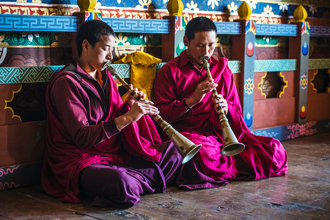 Asiatische Mönche spielen Instrumente auf dem Tempelboden, Bhutan, Königreich Bhutan