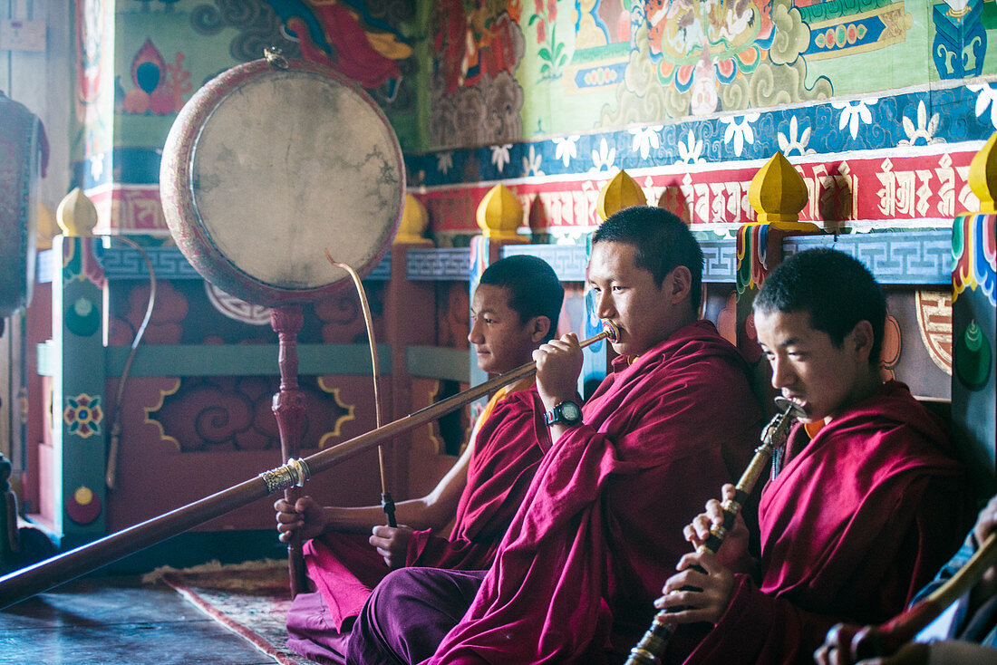 Asiatische Mönche spielen Instrumente auf dem Tempelboden, Bhutan, Königreich Bhutan