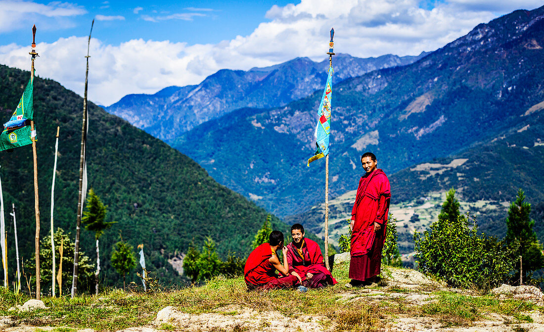 Asiatische Mönche mit Flagge auf abgelegenen Hügeln, Bhutan, Königreich Bhutan