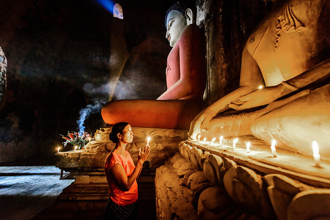 Asiatische Frau zündet Kerze im Tempel an, Myanmar