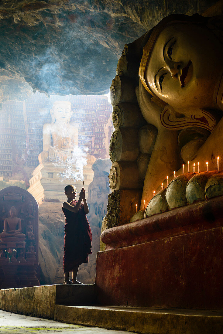 Asiatischer Mönch zündet Weihrauch im Tempel an, Myanmar