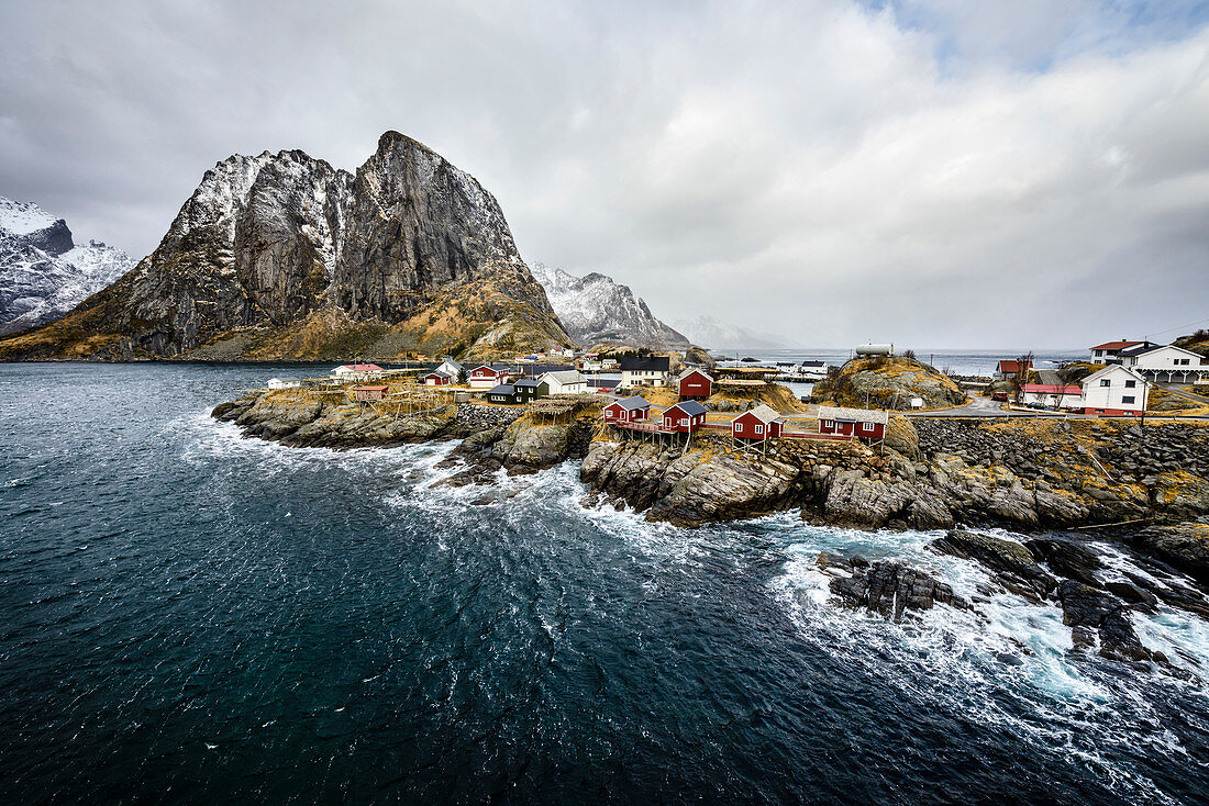 Snowy mountains overlooking rocky coastline, Reine, Lofoten Islands, Norway