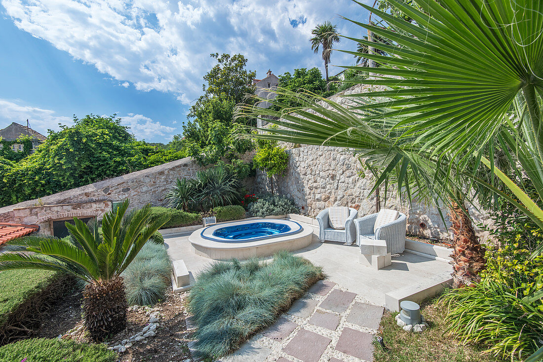 Soaking pool and armchairs on hillside patio, Coratia