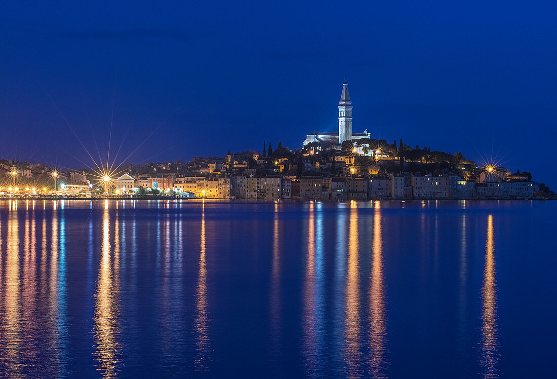 Illuminated coastal city reflected in still water, Rovinj, Istria, Croatia