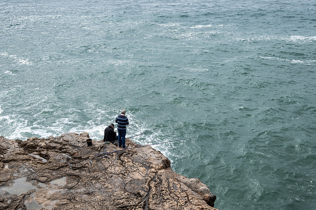 Fisherman on a cliff over the sea, Cascais, Portugal