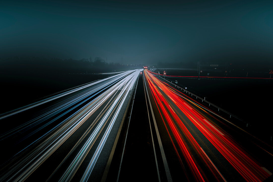 Lichtspuren auf einer Autobahn bei Nacht im Nebel