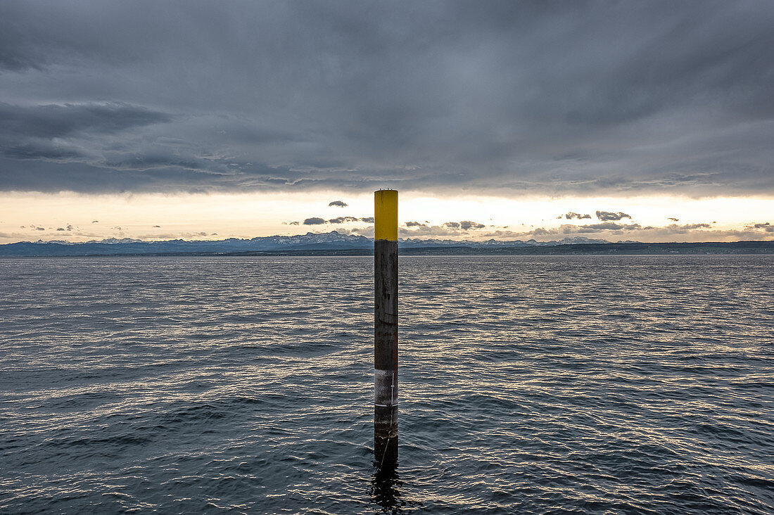 View of Lake Constance with metal pole standing in the water, Meersburg, Baden-Wuerttemberg, Germany