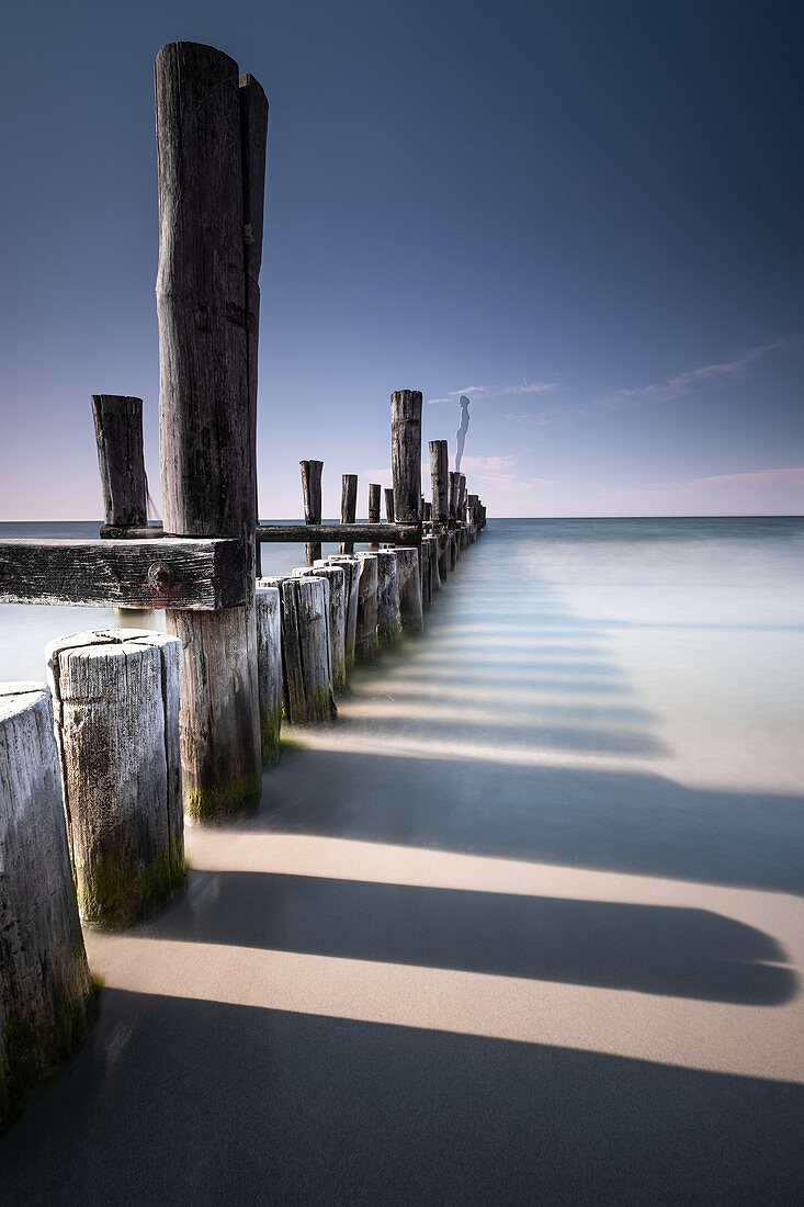 View of the wooden pillars from the old wooden footbridge on the Baltic Sea beach of Zingst, Mecklenburg-West Pomerania, Germany