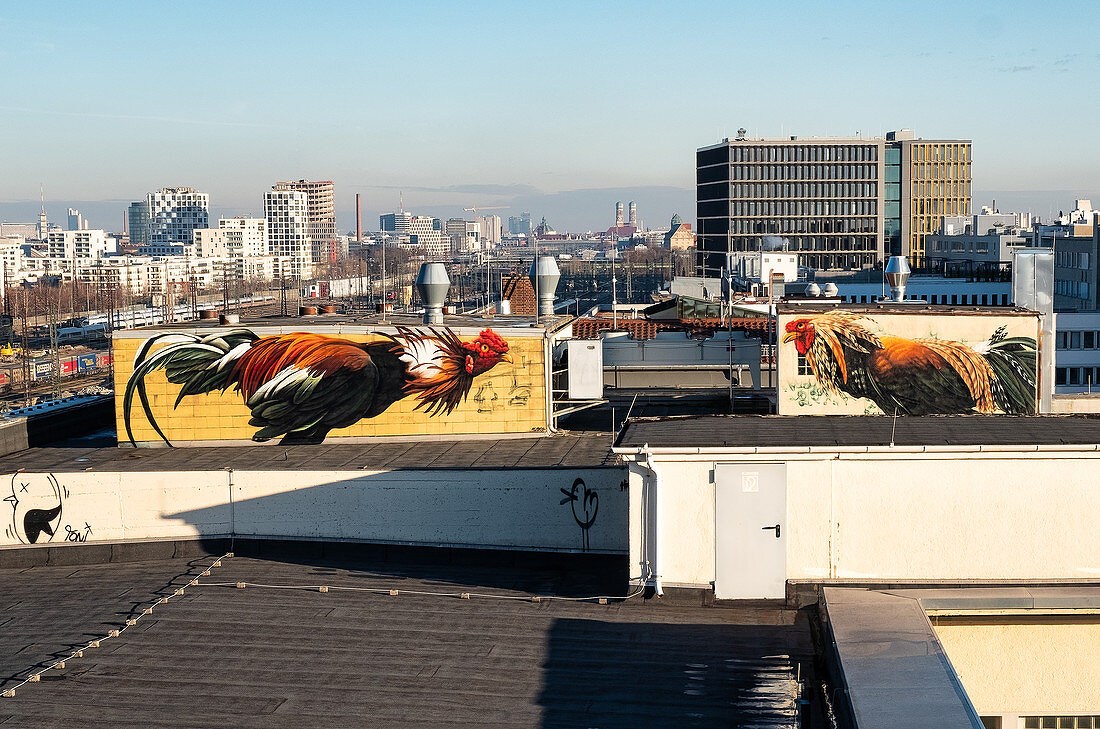 Street art above the roofs of Munich, depicting two roosters, Munich, Bavaria, Germany