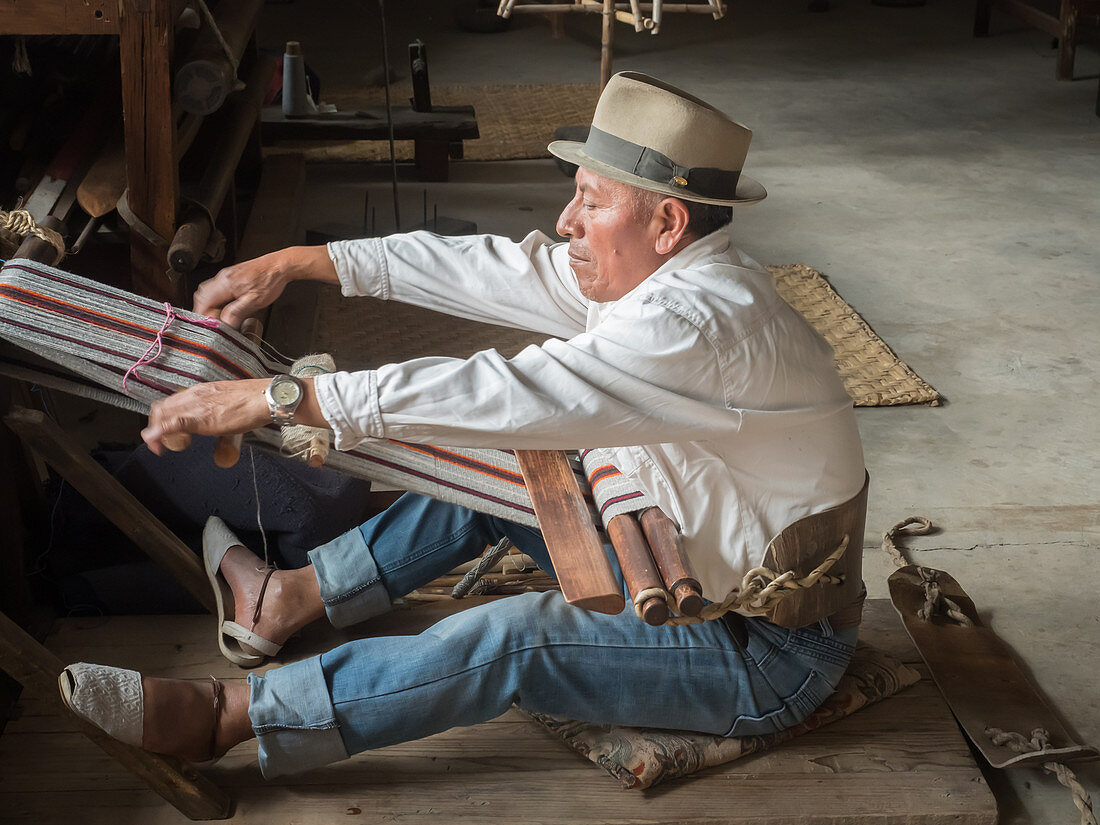 Indigenous man weaving with a backstrap loom, Otavalo, Ecuador, South America