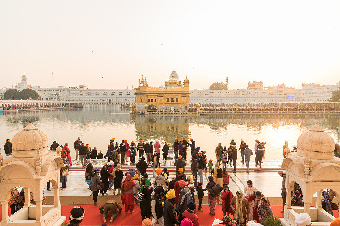 Menschenmenge versammelt sich, um zu beten und den Sonnenuntergang im Goldenen Tempel, Amritsar, Punjab, Indien, Asien zu beobachten