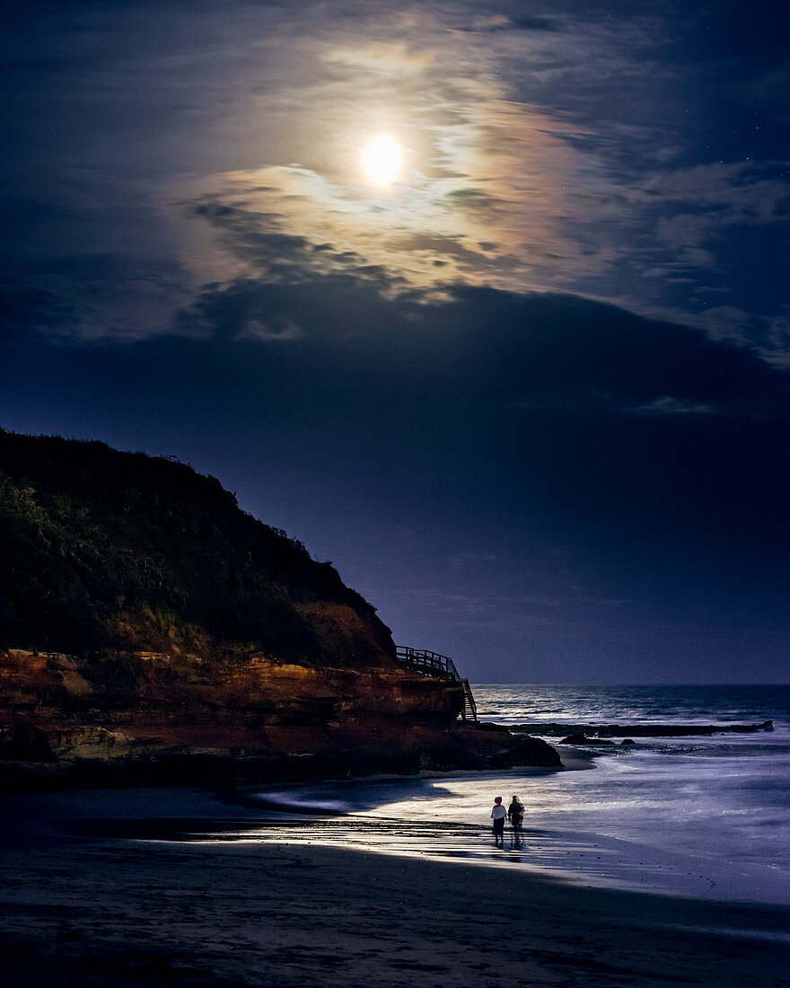 Zwei beim Paddeln beim Vollmond kurz nach einer Sonnenfinsternis in Orcombe Point, Exmouth, Devon, England, Großbritannien, Europa