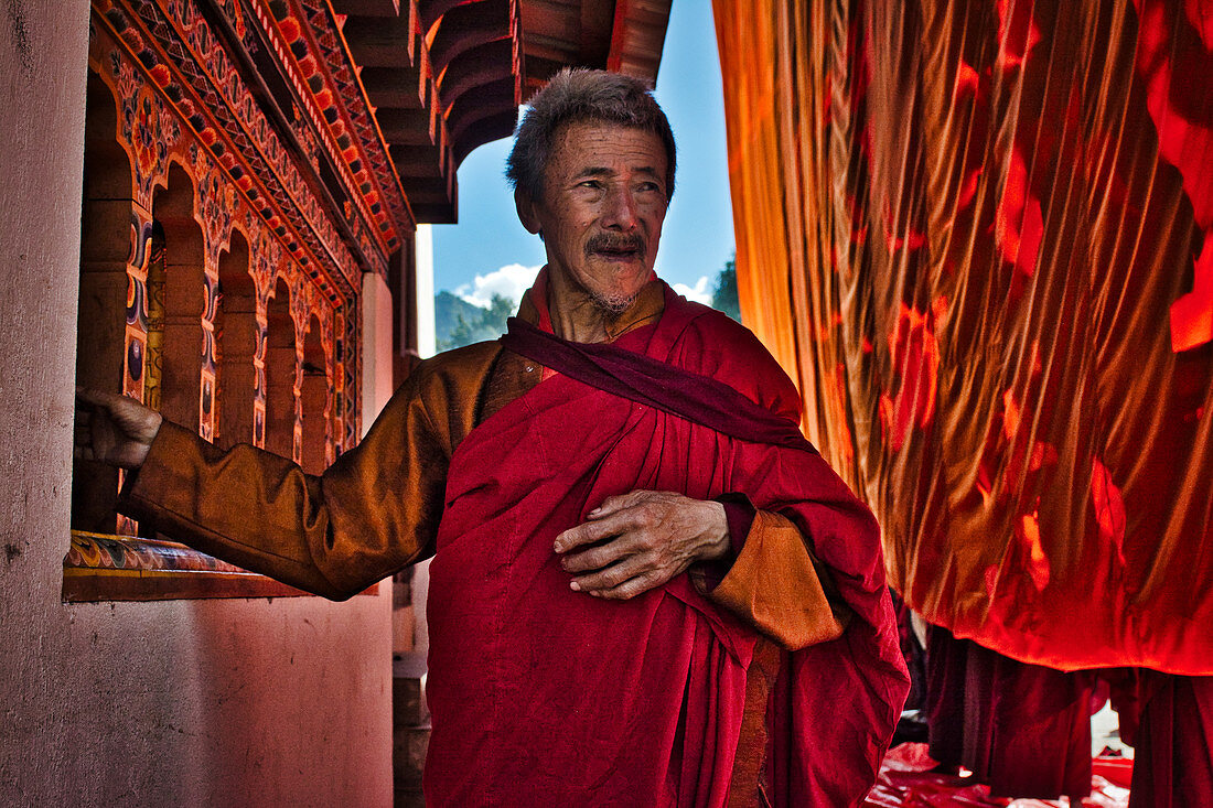 Old monk behind the Great Thanka at festival in Gangteng Monastery, Phobjikha Valley, Bhutan, Himalayas, Asia