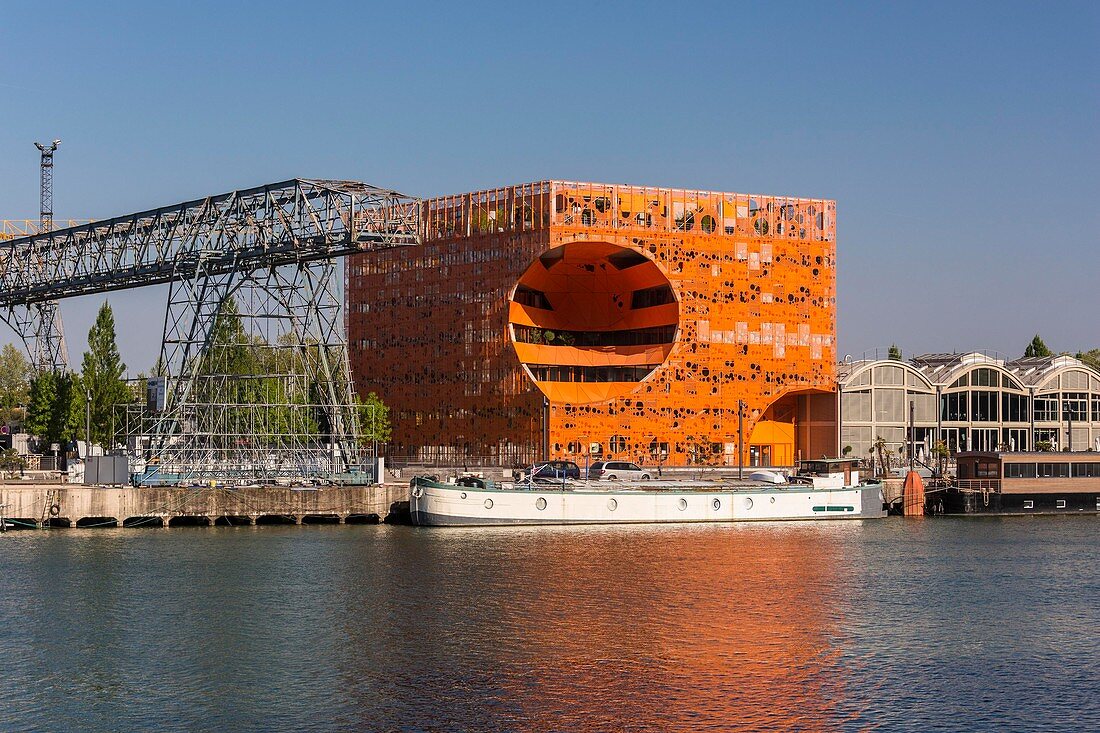 France, Rhone, Lyon, La Confluence new district in the South of the Presqu'ile (Peninsula), Quai Rambaud, the Orange Cube by Dominique Jakob and Brendan MacFarlane architects and the green building of Euronews headquarters in the background and the formerportico and overhead crane situated on the former site of Port Rambaud