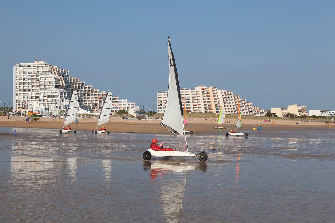 France, Vendee, Saint Jean de Monts, land sailing on the beach and seafront buildings in the background