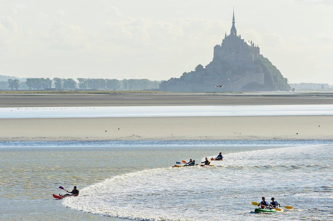 France, Manche, Mont Saint Michel bay, listed as World Heritage by UNESCO, kayaking against the tidal bore at Pointe du Grouin Sud, tidal phenomenon forming a wave at rising tide, Mont Saint Michel in the background