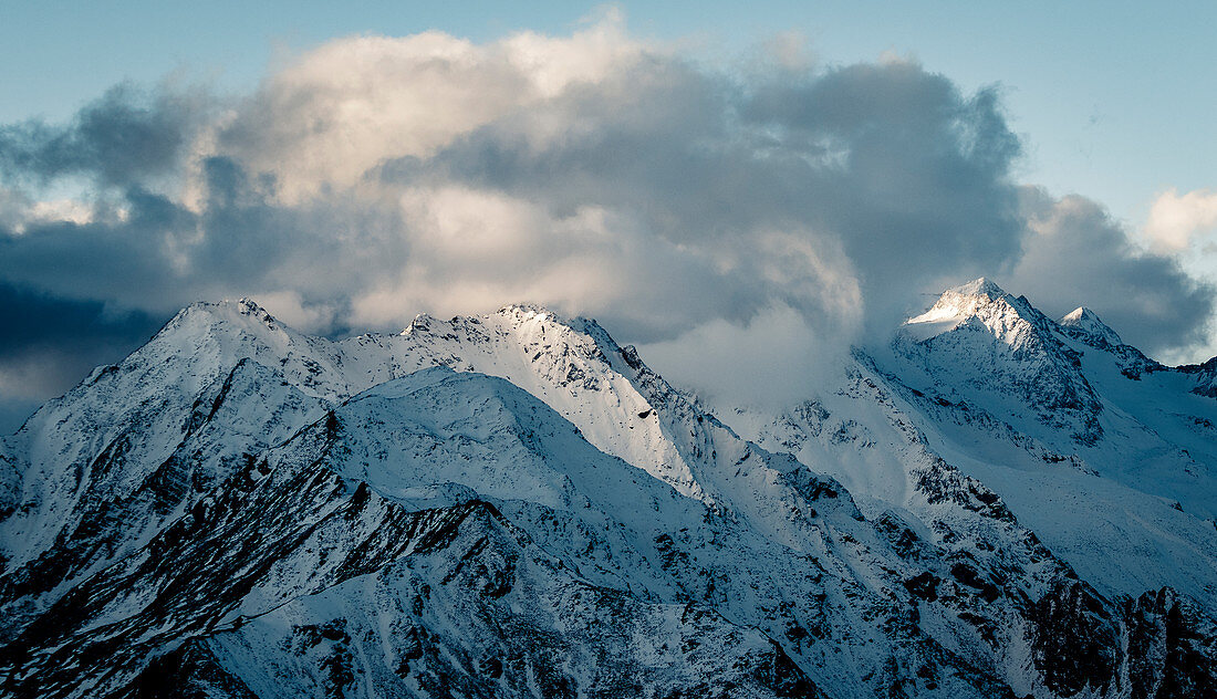 Dramatische Wolkenstimmung über verschneiten Stubaier Alpen, Tirol, Österreich