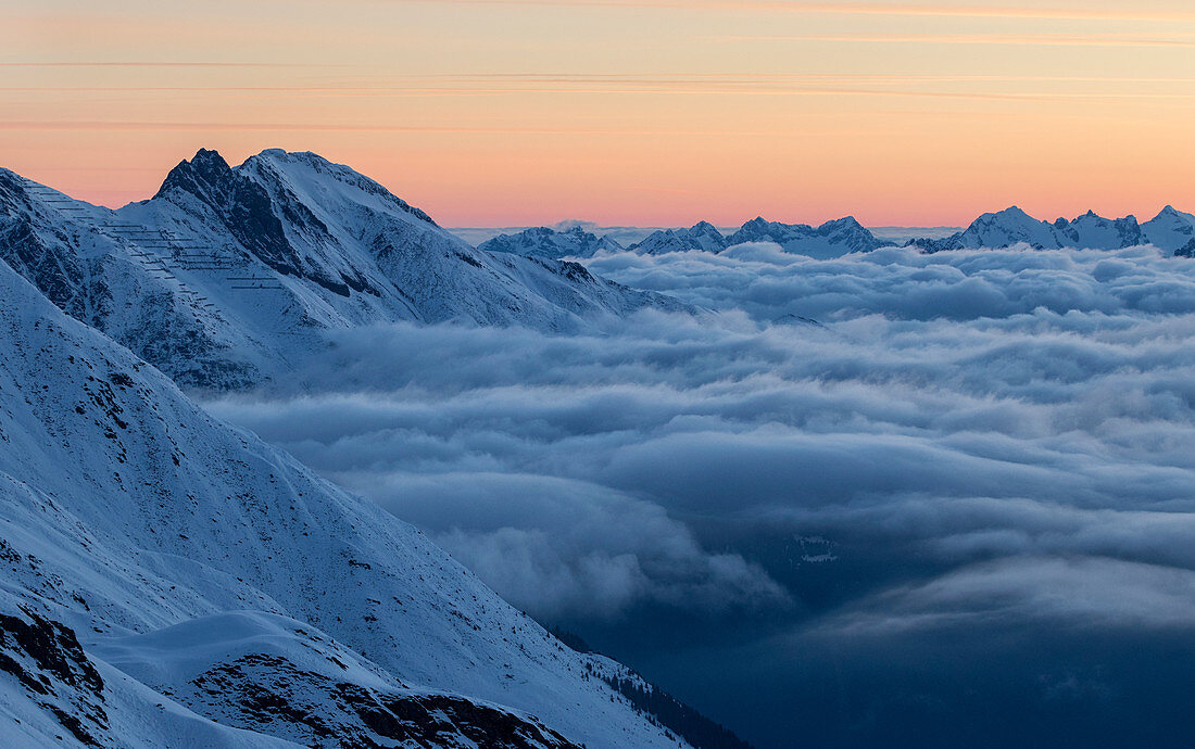Morgenröte über winterlicher Hochgebirgslandschaft mit Wolkenmeer, Zischgeles, Sellrain, Tirol, Österreich