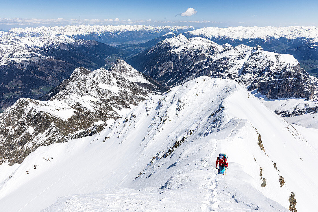 Alpine climber ascending the ridge with crampons and pimples in winter, Habicht, Stubai Alps, Tyrol, Austria