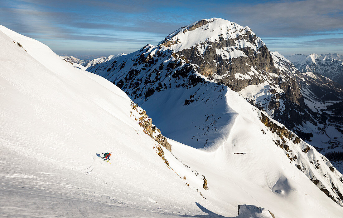 Skifahrerin zieht ihre Spur durch felsdurchsetztes Gelände