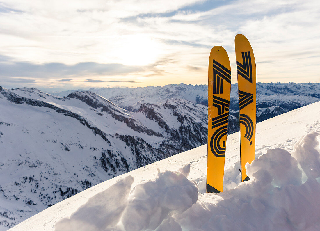 Ein Paar Ski steckt vor winterlicher Hochgebirgslandschaft im Schnee, Tirol, Österreich