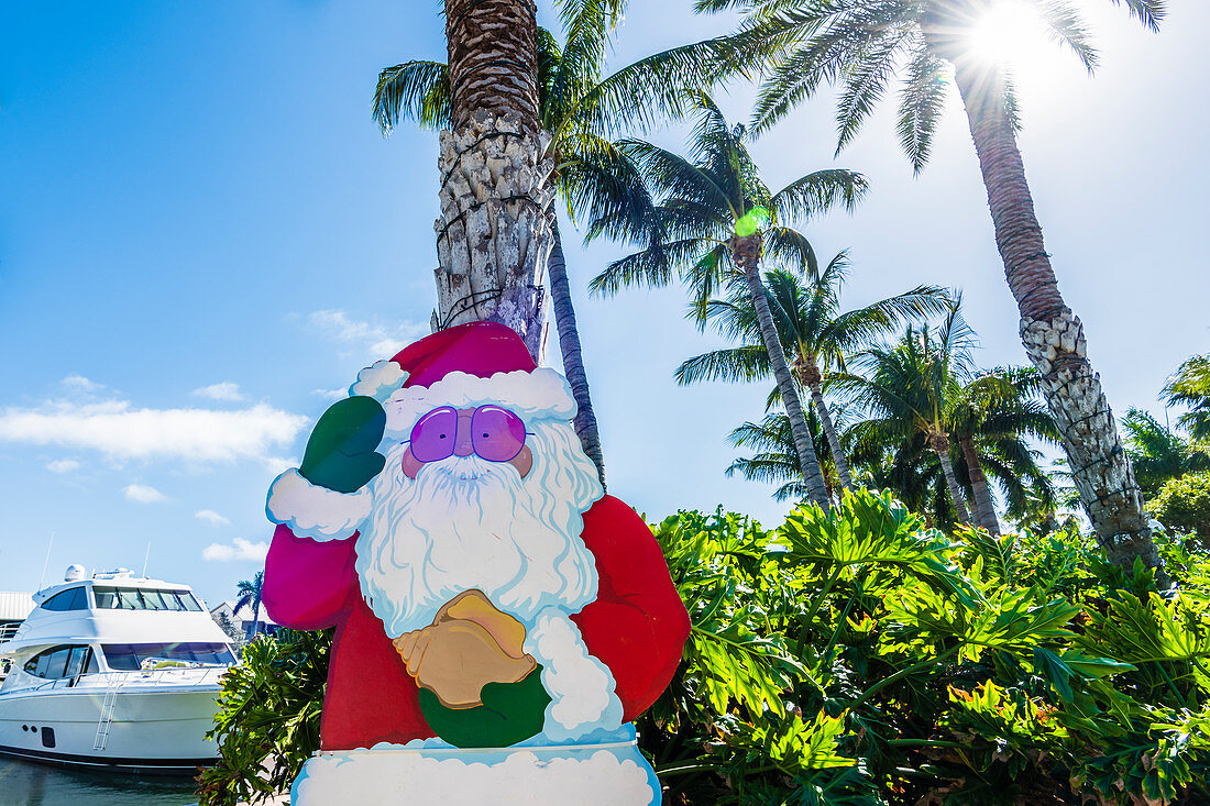 A Santa Claus figure under palm trees in the back light, Fort Myers Beach, Florida, USA