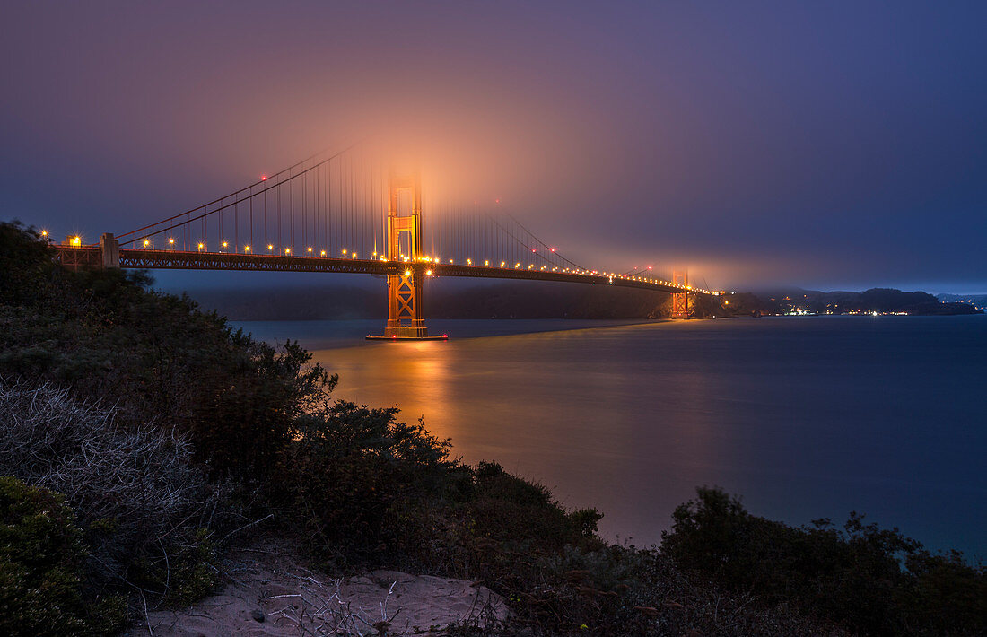 Golden Gate Bridge in the fog at night, San Francisco, USA