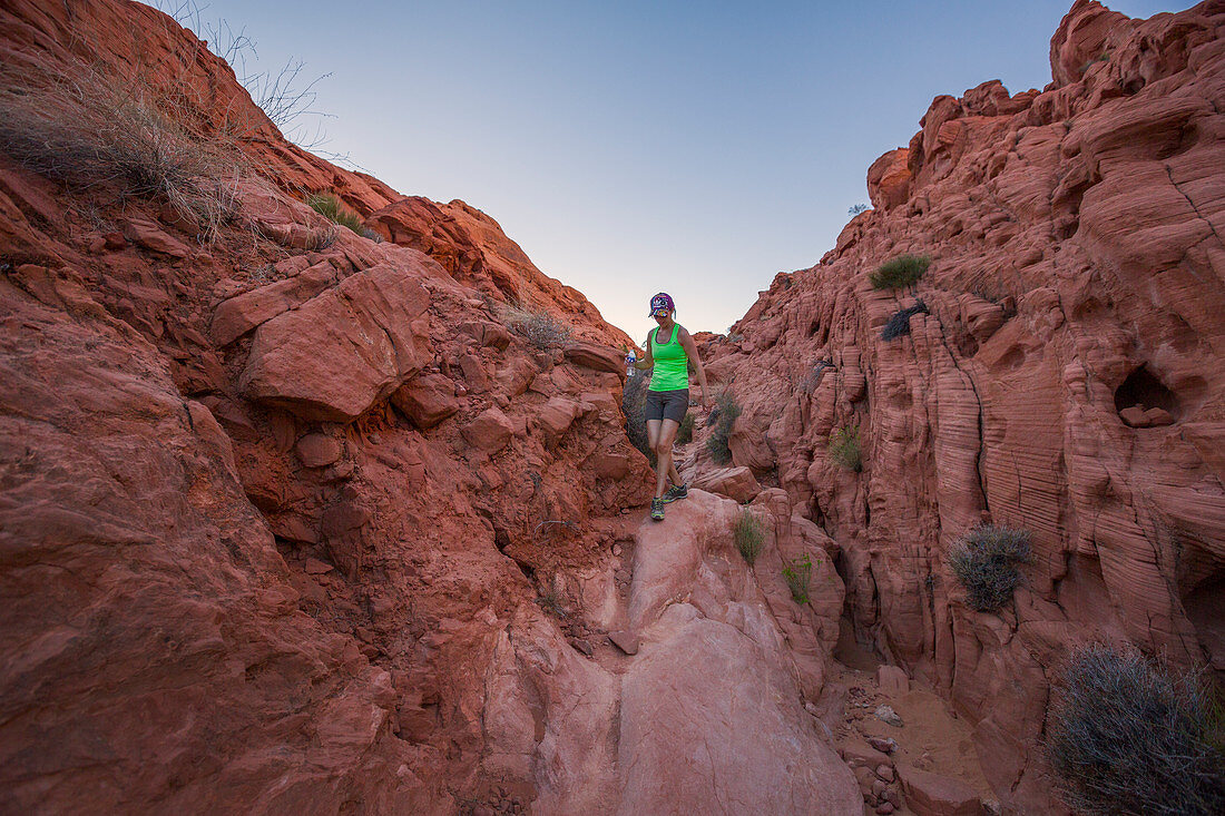 Woman hikes through the Valley of Fire at dusk, USA