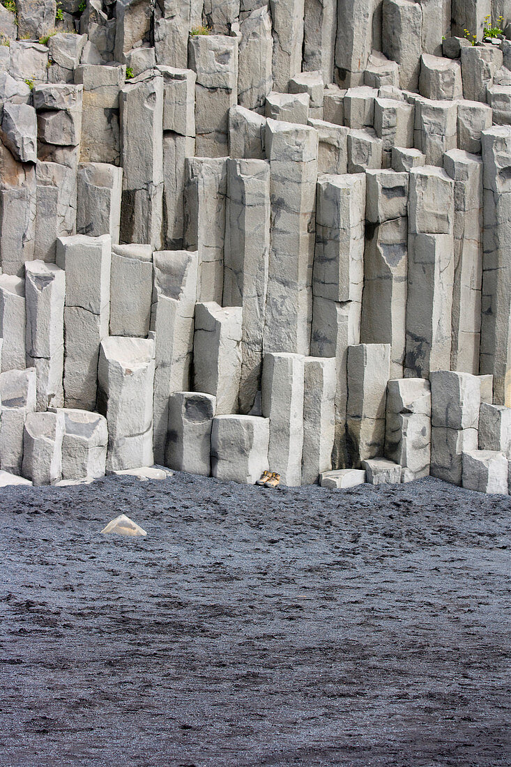 Basalt columns on the beach with parked hiking boots, Vik i Myrdal, South Iceland, Iceland, Europe