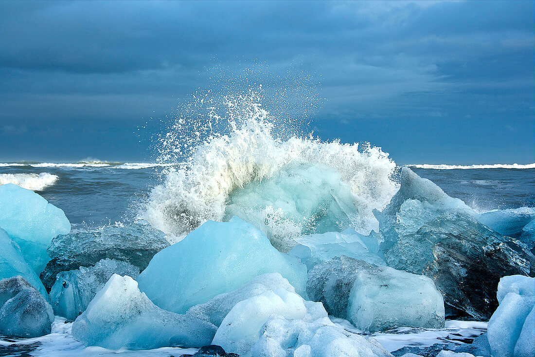 Eisschollen und Wellen am schwarzen Diamant-Strand im Südosten Islands, Breidamerkursandur, Island, Europa