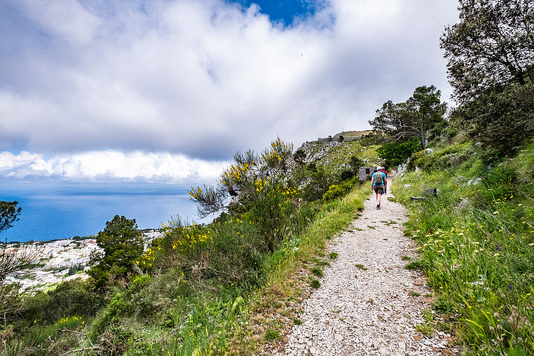 Hikers on Monte Solaro overlooking Anacapri, Capri Island, Gulf of Naples, Italy