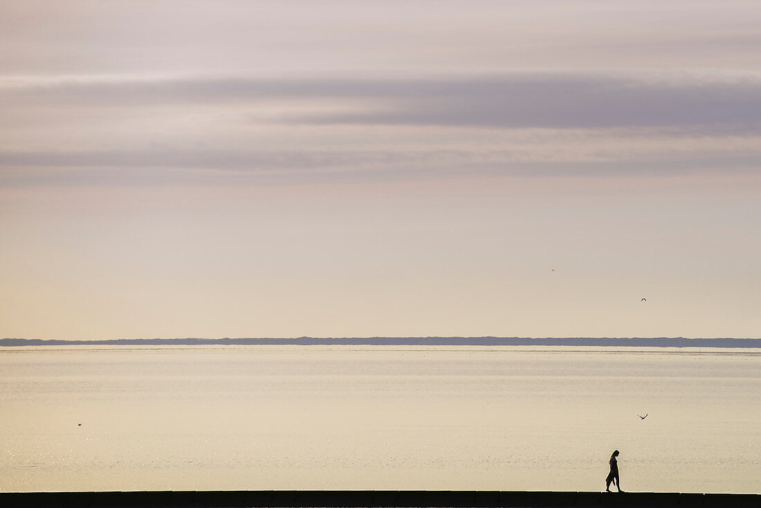 Woman with long hair strolls along the beach. Germany, East Frisia, north