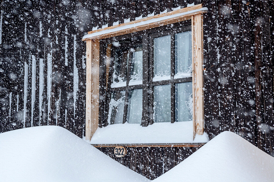 Hut facade with window during snowfall, Tegelberghaus, Tegelberg, Ammergau Alps, Swabia, Bavaria, Germany