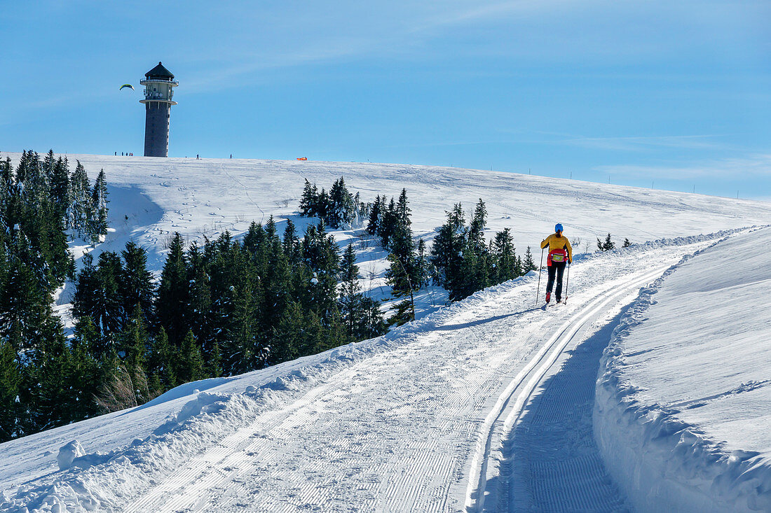 Woman cross-country skiing runs towards Feldberg, Feldberg, Schonach-Belchen skiing trail, Black Forest, Baden-Württemberg, Germany