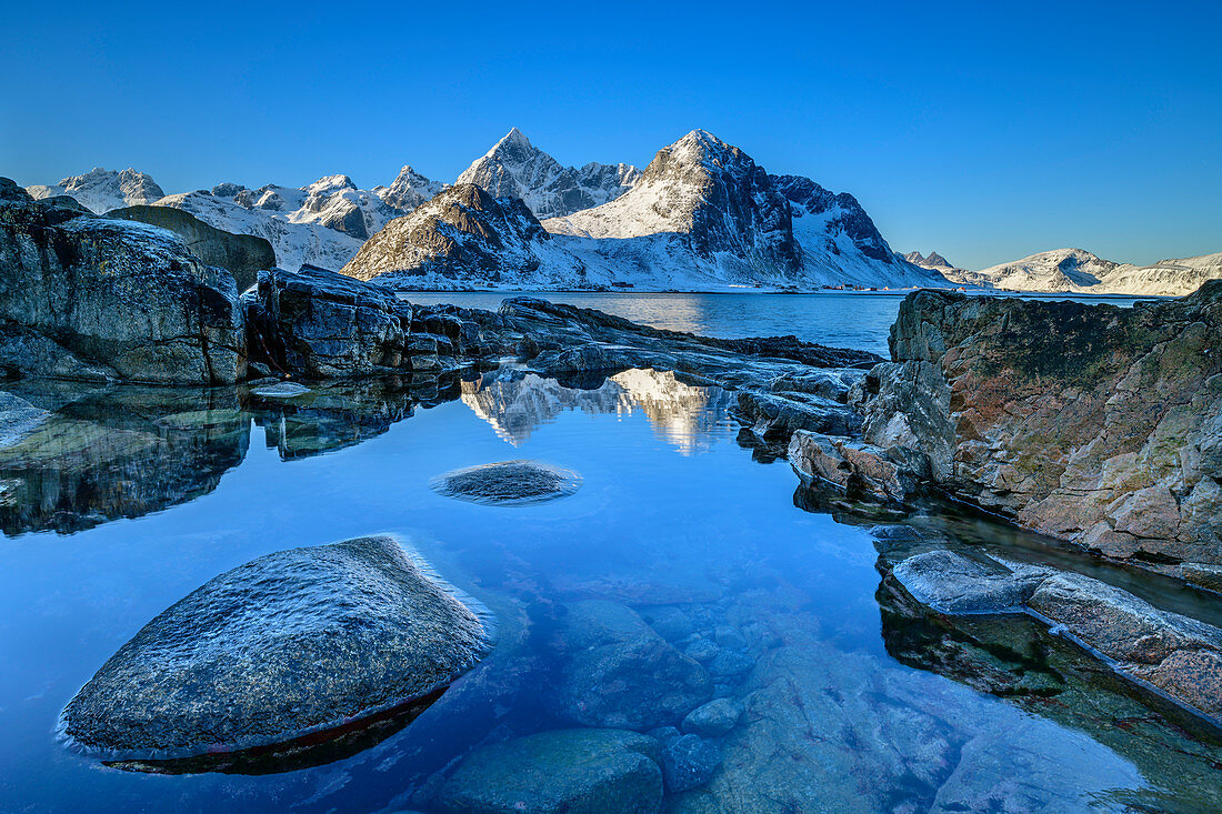 Snowy mountains are reflected in lake, Vareid, Lofoten, Nordland, Norway