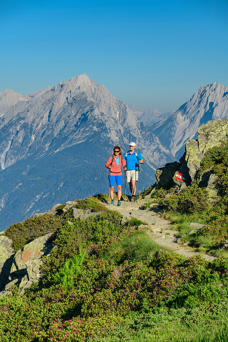 Woman and man hike to the Kellerjochhütte, Karwendel in the background, Kellerjochhütte, Tux Alps, Tyrol, Austria