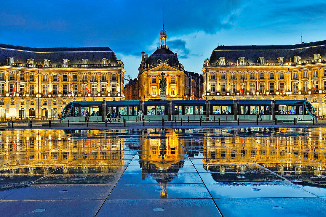 Frankreich, Gironde, Bordeaux, UNESCO Weltkulturerbe, Place de la Bourse, Hafen von La Lune, Nachtansicht einer Straßenbahn, die sich im Miroir d'Eau widerspiegelt